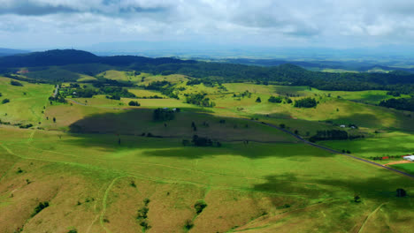 Campos-Verdes-Vibrantes-En-El-Campo-De-Las-Mesetas-De-Atherton,-Queensland,-Australia---Toma-Aérea-De-Drones
