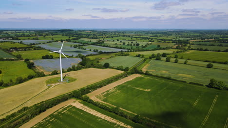 Still-drone-shot-of-wind-turbine-generating-clean-renewable-energy-in-farm-fields-and-countryside,-Northamptonshire,-England