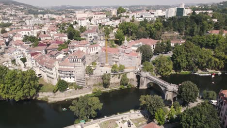 Breathtaking-aerial-shot-of-riverside-historical-monastery-of-Sao-Goncalo-and-bridge