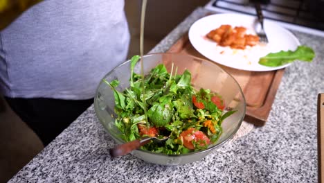 Vinaigrette-In-Eine-Schüssel-Mit-Frischem-Grünen-Salat-Auf-Der-Küchenarbeitsplatte-Gießen