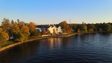 Filmische-Luftaufnahme-Eines-Hauses-Am-See,-Luxuriöse-Immobilien-Mit-Blick-Auf-Einen-Wunderschönen-Sonnenuntergang