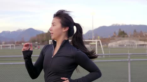 Young-female-athlete-running-on-track-slow-motion-Medium-shot