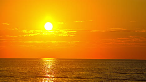 Romantischer-Goldener-Sonnenunterganghimmel-über-Ruhigem-Ozeanwasser