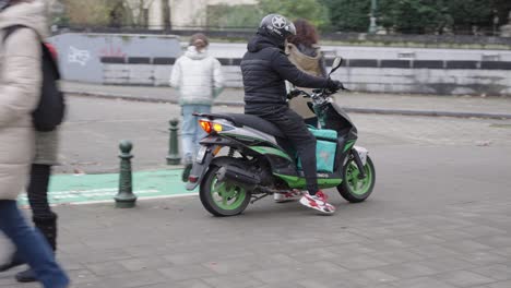 Deliveroo-food-delivery-rider-on-a-scooter-in-Brussels,-Belgium