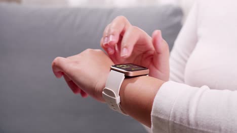 Close-up-shot-of-a-woman-hand-who-touch-and-scrolling-on-a-smartwatch-in-order-to-quickly-check-application-connect