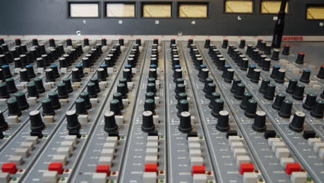 Close-up-of-vintage-audio-mixing-desk-EQ-pan-pot-knobs-and-buttons