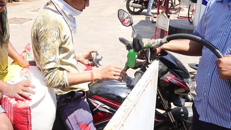 Petrol-pump-employee-filling-up-fuel-in-a-motorcycle