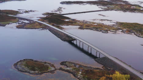 Aerial-View-Of-Bridge-At-Atlantic-Ocean-Road-Over-Norwegian-Sea-With-Island-In-Norway