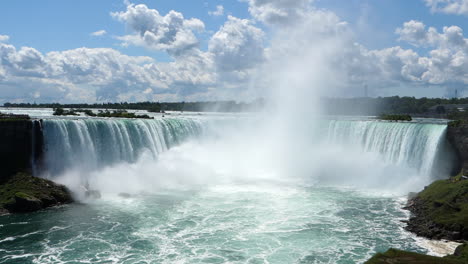 Niagara-Falls-with-High-Mist-in-the-Middle-on-a-Sunny-Day-with-Clouds,-Tripod-Wide-Shot,-Slow-Motion