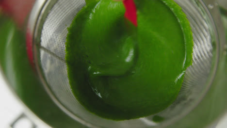 Straining-spinach-puree-chutney-carefully-closeup