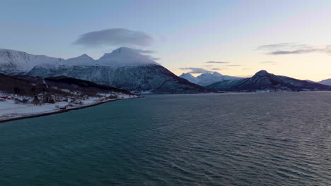 Picturesque-Landscape-Of-Sea,-Snowy-Mountain,-And-Arctic-Village-At-Polar-Night-In-Northern-Norway