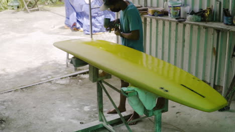 High-angle-gimbal-shot-of-shaper-painting-surfboard