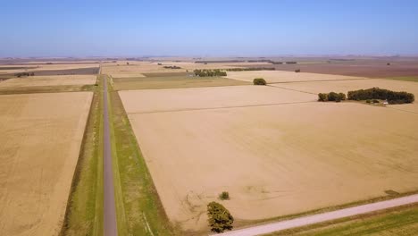 Aerial-View-Of-Highway-Road-Through-Wheat-Fields-Landscape---drone-shot