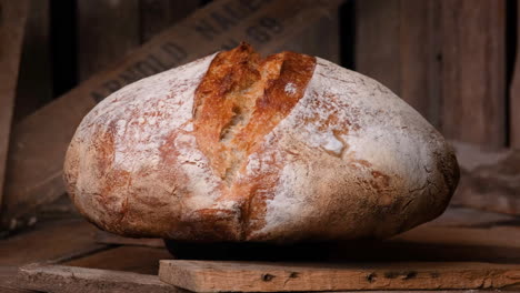 Whole-Loaf-Of-Sourdough-Bread-Rotating-On-Wooden-Table