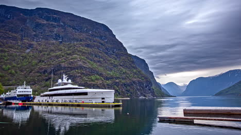 Zeitraffer-Der-Ankunft-Des-Bootes-Im-Hafen-Von-Flam-Zwischen-Norwegischen-Bergen-Und-Bewölktem-Himmel---Anlegen-Einer-Luxusyacht-Am-Pier-In-Norwegen