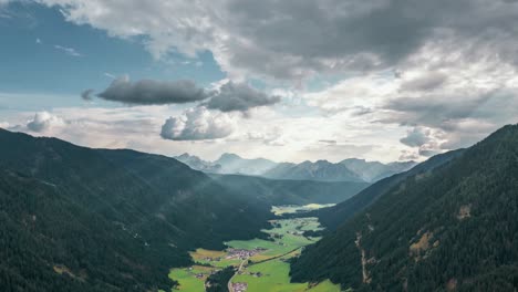 Hyperlapse-of-an-alpine-valley-close-to-the-Dolomites-with-moving-clouds,-mountains,-and-sunbeams
