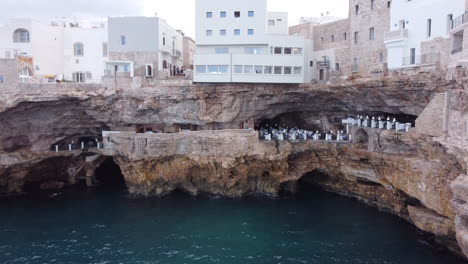Coastal-caves-under-the-Italian-village-of-Polignano-A-Mare,-Bari,-drone