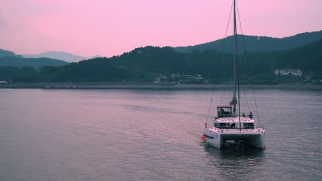 Touristen-Auf-Einem-Katamaran,-Die-Während-Des-Rosafarbenen-Sonnenuntergangs-In-Südkorea-Im-Resort-Auf-Der-Insel-Geoje-Ankommen