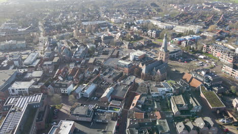 Flying-towards-large-church-in-an-old-town-center-in-Barneveld,-the-Netherlands