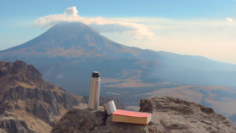 Libro-Y-Café-En-Las-Rocas-Y-El-Volcán-Popocatepetl-Al-Fondo