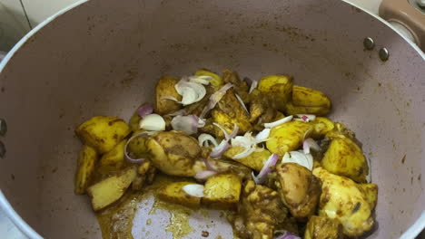 Fresh-Sliced-Onions-Being-Placed-Into-Pot-Of-Curry-Chicken-With-Diced-Potatoes