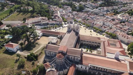 Aerial-pan-shot-above-historical-complex-Alcobaça-monastery-overlooking-at-parish-townscape