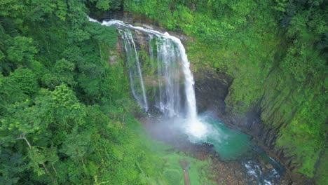 Aerial-rising-over-Eco-Chontales-waterfall-falling-down-turquoise-natural-pool-surrounded-by-green-tropical-woods,-Costa-Rica