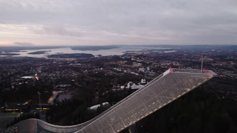 Holmenkollbakken-Ski-Jumping-Hill-At-Dusk-With-Panoramic-View-Of-The-City-In-Oslo,-Norway