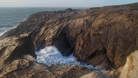 Water-Shooting-Out-From-The-Rocks---Blowhole-In-Porth-Island,-Newquay,-Cornwall---wide-shot