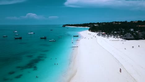 Fantastic-aerial-flight-fly-forwards-drone-shot-over-crystal-clear-turquoise-water-white-sand-beach-fishing-baot-Paradise-on-zanzibar,-africa-2019