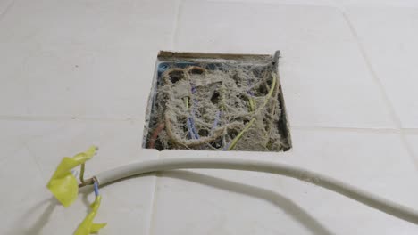 A-close-up-shot-of-an-electrical-box-in-a-bathroom-completely-covered-in-dust,-cobwebs-and-dirt,-a-serious-fire-hazard-which-requires-cleaning-before-installing-a-new-electrical-appliance