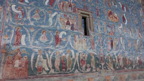 Detail-Der-Wandmalereien-An-Blauen-Schattenwänden-Im-Kloster-Voronet-In-Suceava,-Rumänien