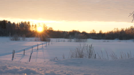 Winter-wonderland-in-rural-area-of-Finland-during-early-morning-sunrise,-pan-right-view
