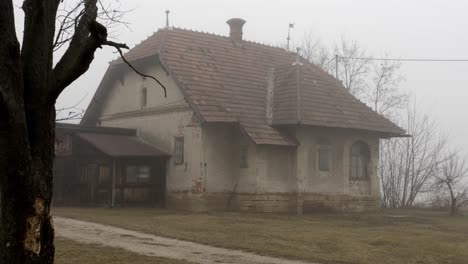 Wide-shot-of-mystic-old-horror-house-on-abandoned-farm-during-cloudy-and-foggy-day