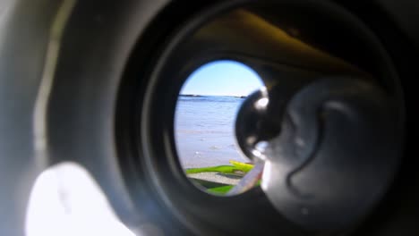 Looking-out-through-the-opening-in-an-aluminum-beverage-can-discarded-carelessly-on-the-beach-by-a-careless-person