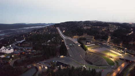 Aerial-View-Of-Holmenkollbakken-Ski-Jumping-Hill-And-Museum-In-Oslo,-Norway-At-Sunset