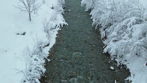 Aerial-shot-of-a-snow-covered-mountain-creek