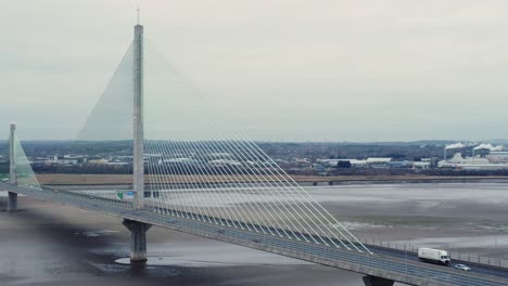 Aerial-view-Mersey-Gateway-cable-stayed-toll-bridge-traffic-crossing-River-Mersey-at-low-tide