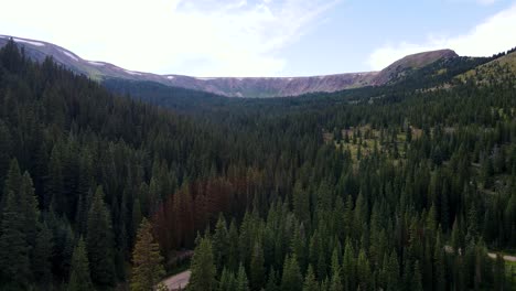 Pinien-Und-Schneebedeckter-Grat-In-Den-Rocky-Mountains-In-Colorado-|-Luftbild-Nach-Oben-Schwenken-|-Sommer-2021