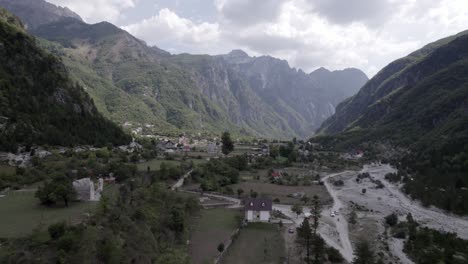 Drone-video-of-frontal-plane-in-the-interior-of-the-theth-valley-in-albania,-on-the-river-Lumi-i-thethit-with-hardly-any-water-in-September