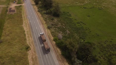 Un-Dron-Sobre-Un-Camión-Que-Transporta-Troncos-Por-La-Carretera-En-Uruguay