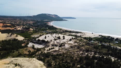 Sandy-dunes-near-tropical-coastal-beach-of-Vietnam,-aerial-high-altitude-view
