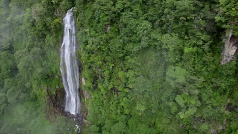 Aerial-truck-left-of-Las-Lajas-waterfall-flowing-down-high-cliff-surrounded-by-rain-forest,-San-Luis-Morete,-Costa-Rica