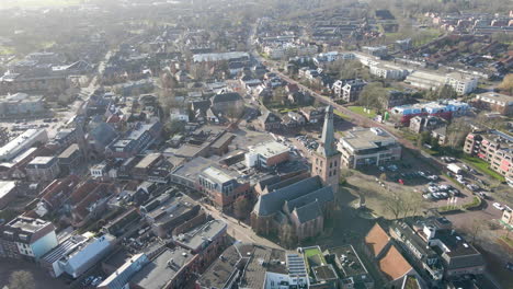 Aerial-orbit-of-large-church-in-an-old-town-center-in-Barneveld,-the-Netherlands