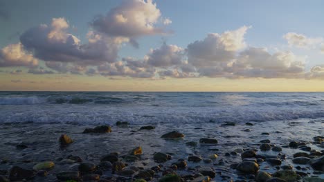 Meereswellen-In-Zeitlupe-An-Einem-Felsigen-Strand-Mit-Dramatischem-Himmel-Im-Hintergrund