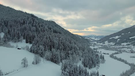 Luftaufnahme-Einer-Schneebedeckten-Bergstadt,-Kurvenreiche-Straße-Durch-Das-Tal