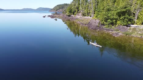 Picturesque-Kayaker-on-Reflective-Lake-Waters-on-Kennedy-Lake,-Laylee-Island,-Vancouver-Island,-Canada