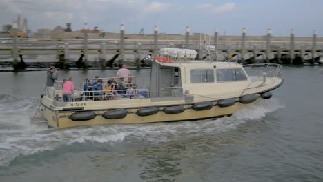 a-pan-of-a-speedboat-filled-with-tourist-to-spot-seals-in-the-waddensea-leave-the-harbour-of-Texel-in-Netherlands
