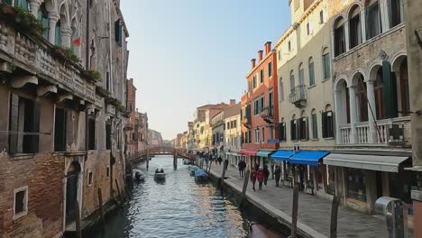 Ponte-de-L'Aseo-and-motorboat-on-canal-of-Cannaregio-district,-Venice-in-Italy,-Europe
