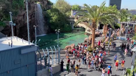Universal-Studios-Hollywood,-Jurassic-World-,-crowd-of-tourists-gathering-by-the-Raptor-Enclosure